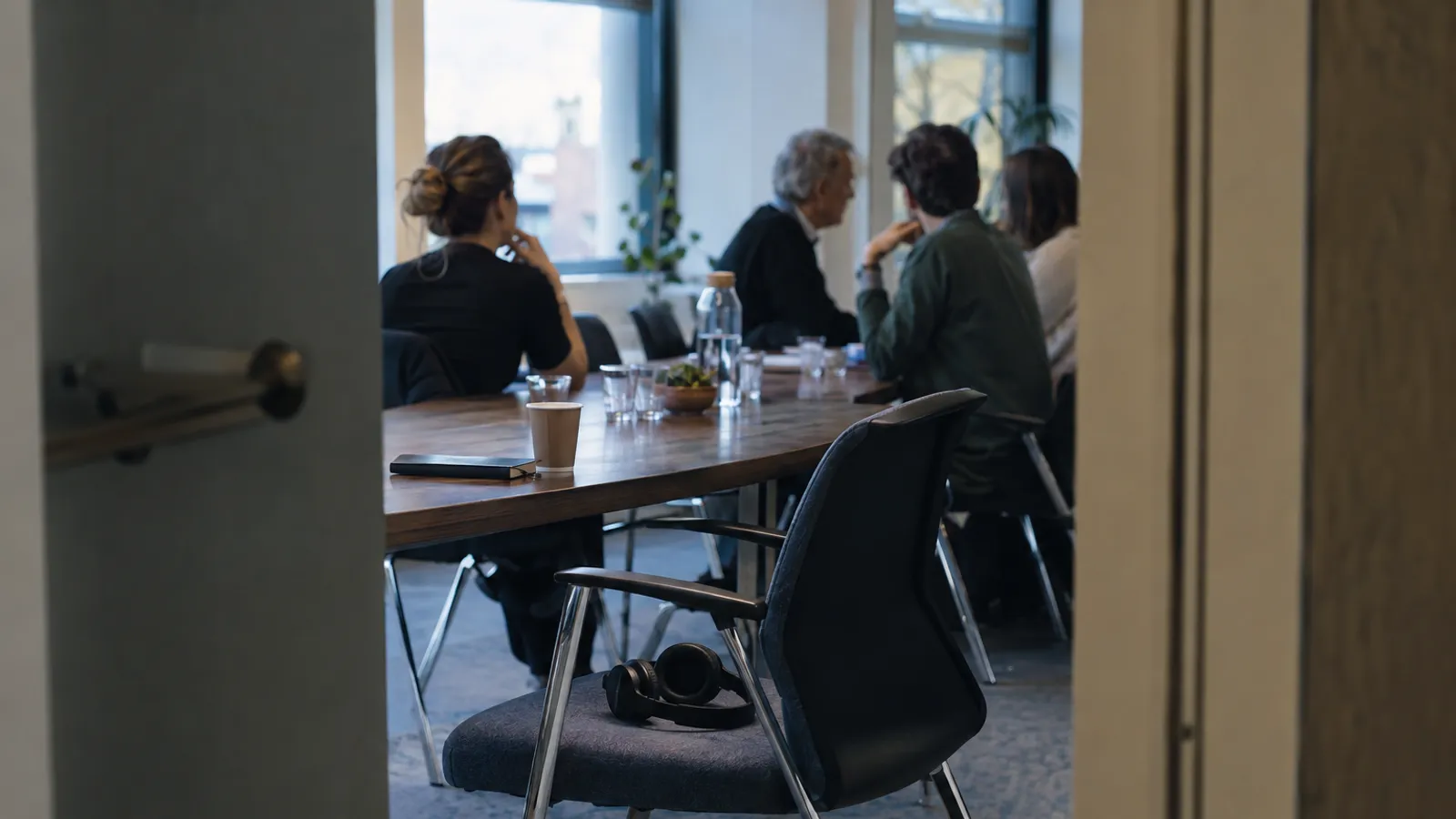 Ein leerer Stuhl mit Kopfhörern neben einem Besprechungstisch im internationalen Meetingraum.